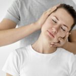therapist-undergoing-physical-therapy-with-female-patient